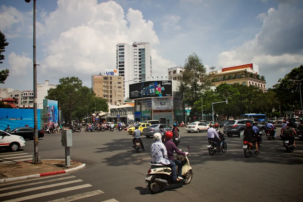 Motorbikes crossing a busy central Ho Chi Minh City intersection near hotels