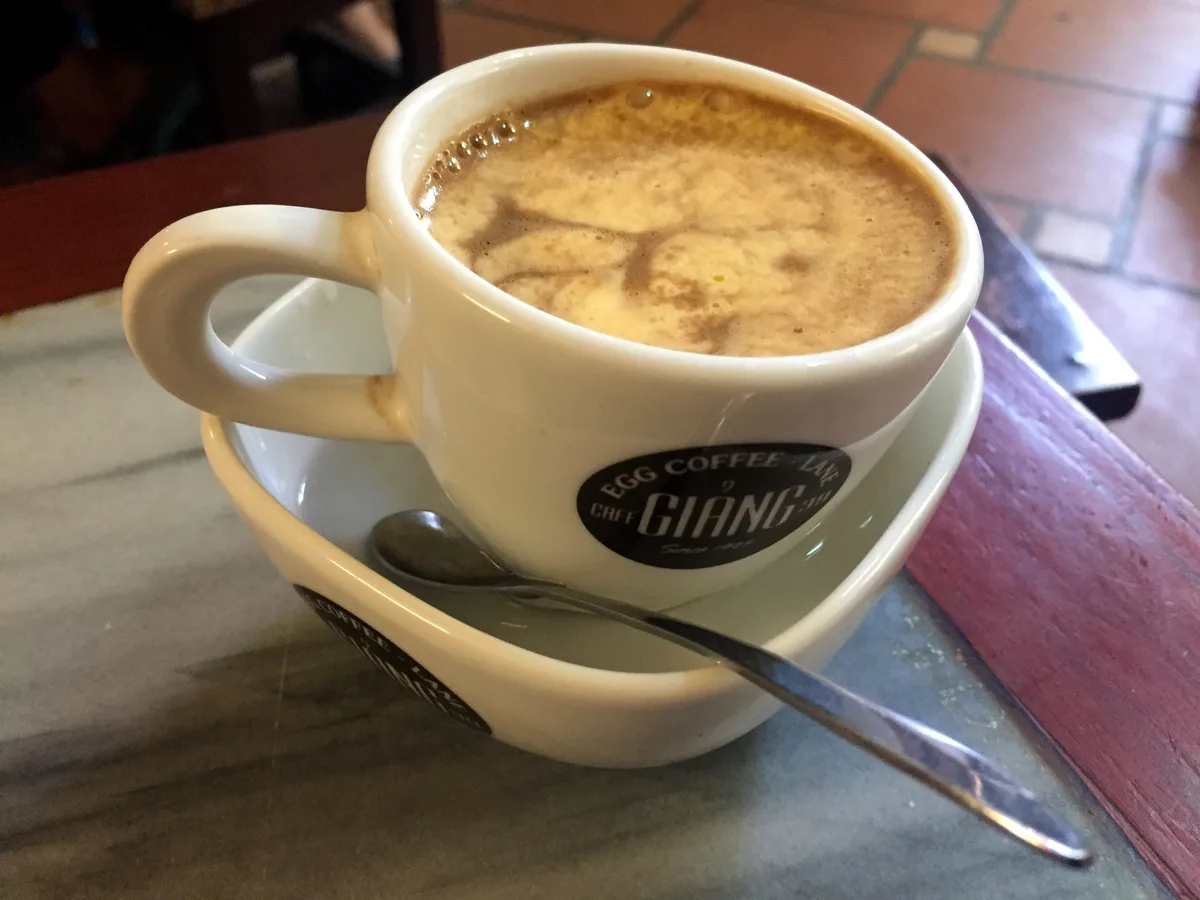 Glass of Hanoi egg coffee served on a café table at Giang Cafe