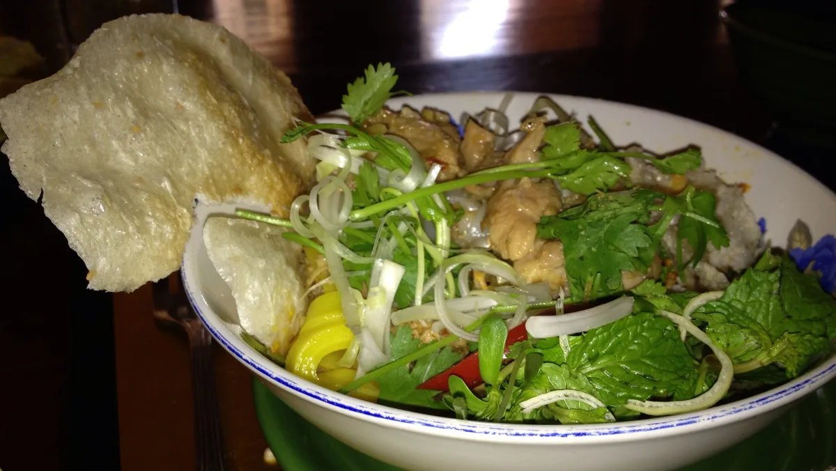 Fresh herbs and noodles served together at a casual Vietnamese restaurant