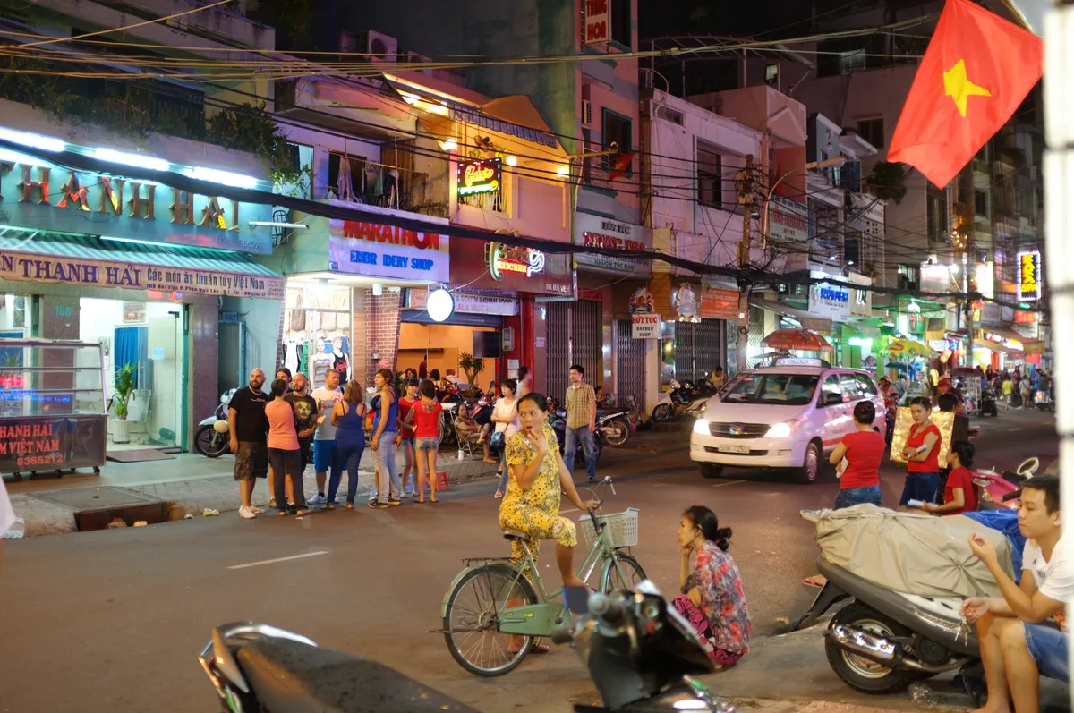 Everyday motorbike traffic and shopfronts on a neighborhood street in Saigon