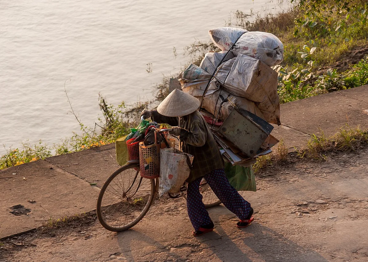 Hue Vietnam A lady with her bike transporting goods, illustrating Must-Try Hue Signature Dishes in this Vietnam travel guide