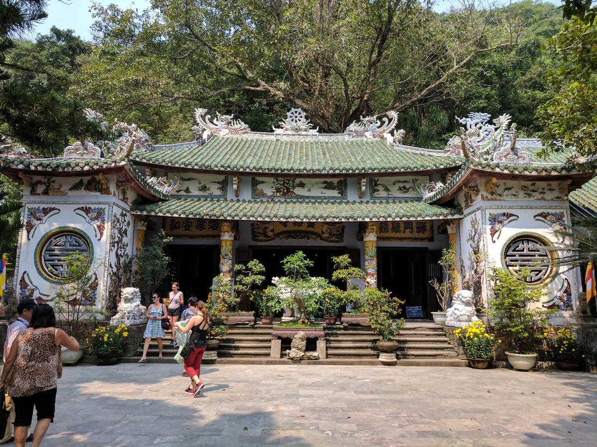 Visitors entering Linh Ung Pagoda among trees at Marble Mountains in Da Nang