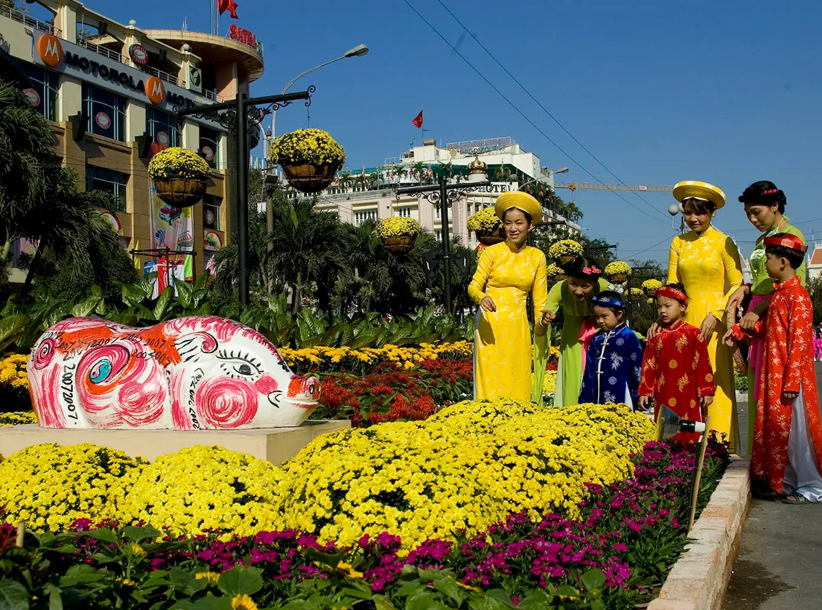 Colorful Tet flower display with traditional costumes at a Vietnam festival